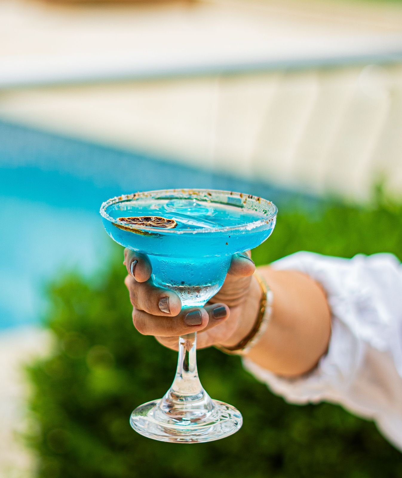 Invitada disfrutando un cóctel azul junto a la piscina