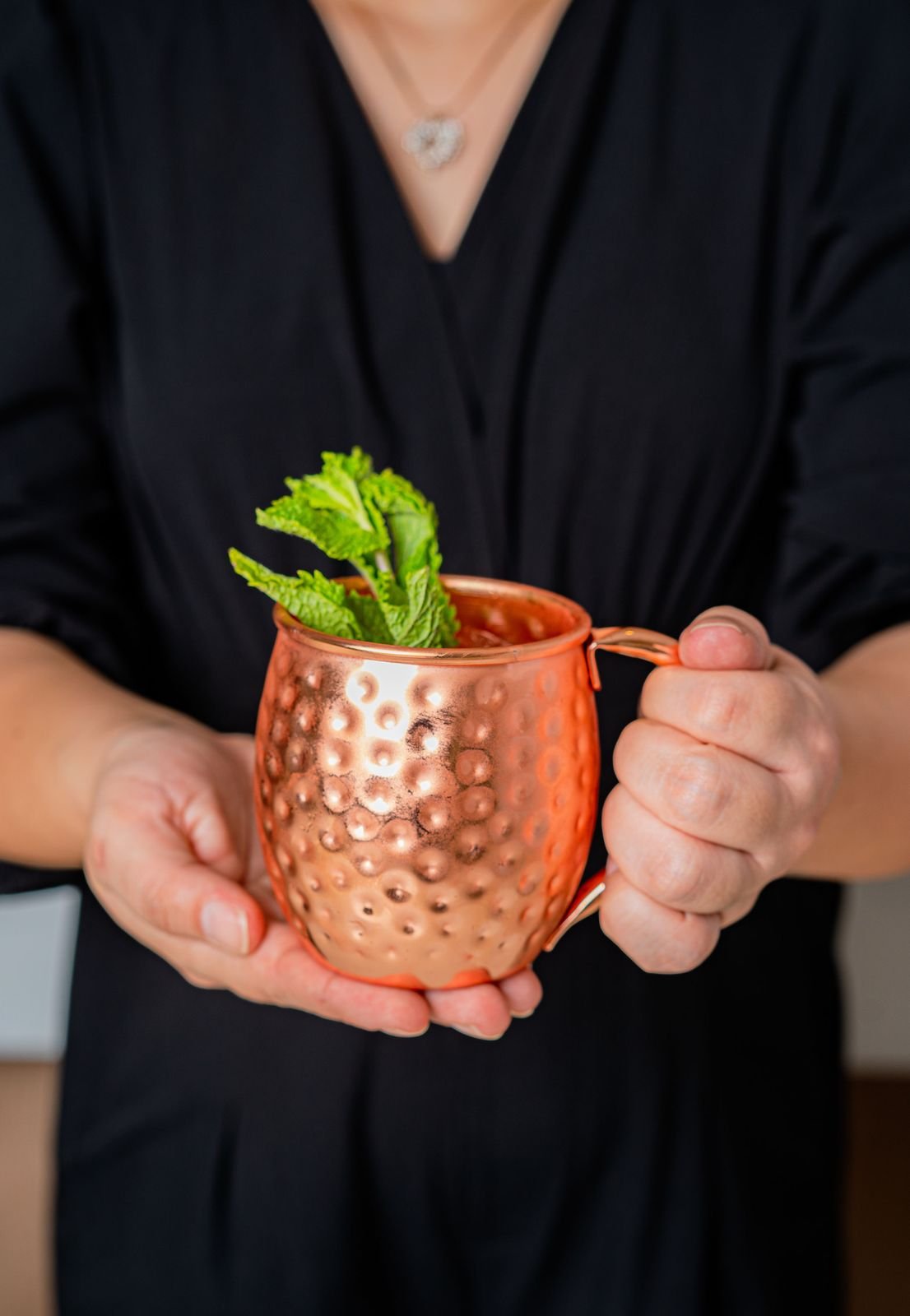 Bartender sosteniendo un moscow mule en jarra de cobre
